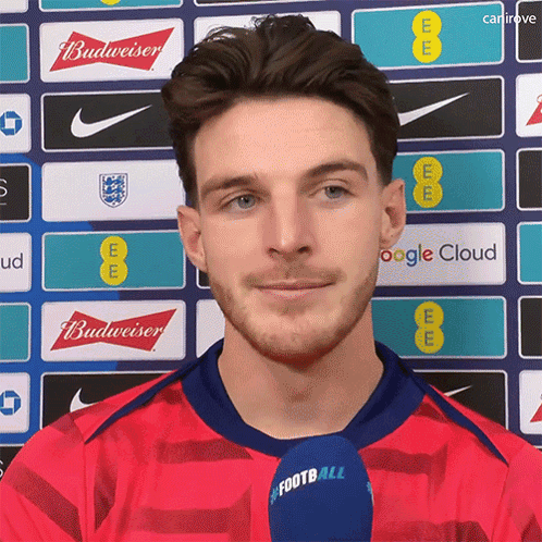A Man In A Red Shirt With A Microphone That Says Football On It GIF