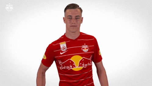 A Man In A Red Shirt With A Red Bull On It GIF