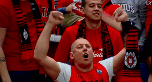 A Man In A Red Shirt With A Scarf Around His Neck That Says Lrt On It GIF
