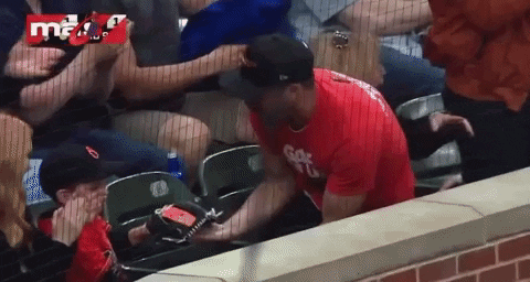 a man in a red shirt with the letter g on it is sitting in a stadium