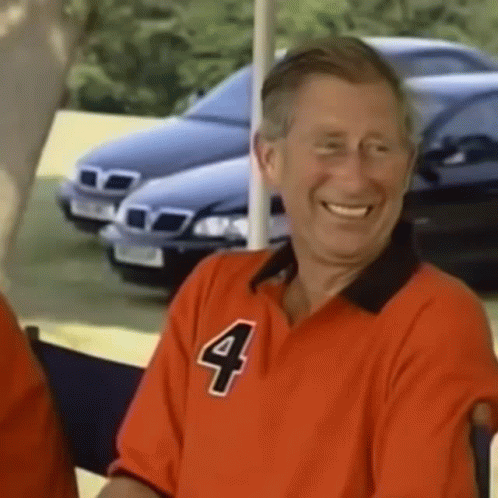 A Man In A Red Shirt With The Number Four On It Is Smiling . GIF