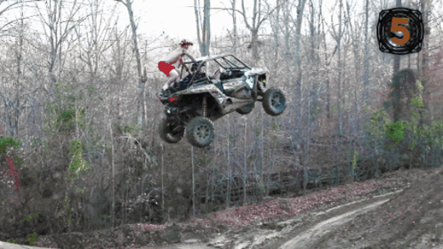 a man in a red shorts is riding a polaris atv in the air