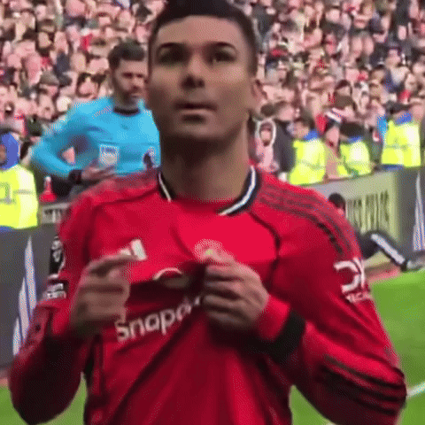 a man in a red snap on shirt stands on a field