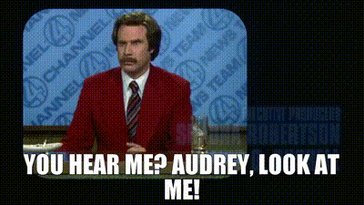A Man In A Red Suit And Tie Is Standing In Front Of A Television And Says You Hear Me ? Audrey Look At Me . GIF