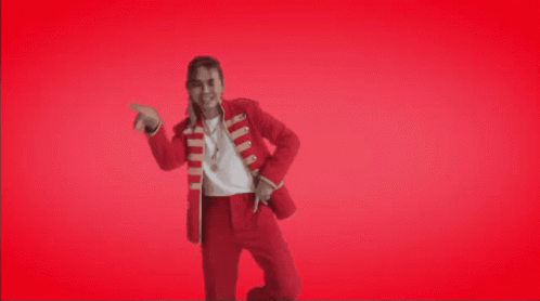 a man in a red suit is dancing in front of a red background that says ' til week end '