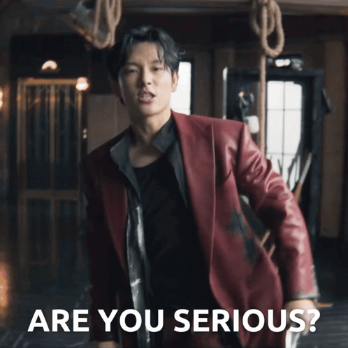 A Man In A Red Suit Is Standing In Front Of Ropes And The Words Are You Serious GIF