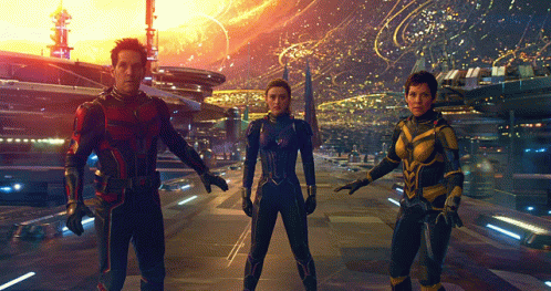 Man In Red Suit Next To Two Women In Blue Suits GIF
