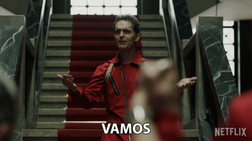 A Man In A Red Suit Is Standing On A Set Of Stairs With A Netflix Logo Behind Him GIF