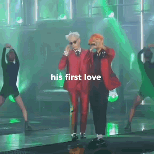 A Man In A Red Suit Stands Next To Another Man With The Words His First Love Written On The Bottom GIF