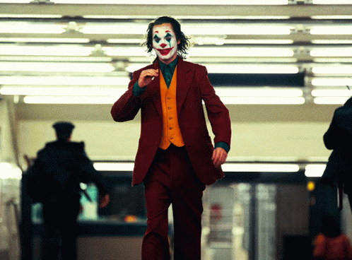 A Man In A Red Suit With A Clown Face GIF