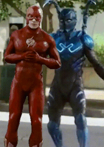A Man In A Red Superhero Suit Stands Next To A Man In A Blue Superhero Suit GIF