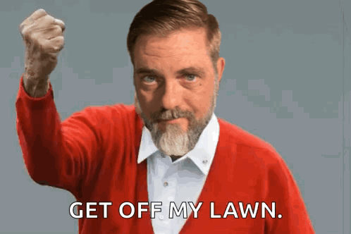 A Man In A Red Sweater Holds His Fist Up And Says " Get Off My Lawn " GIF