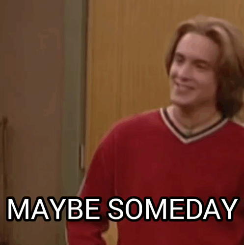 A Man In A Red Sweater Is Standing In Front Of A Door And Smiling . GIF