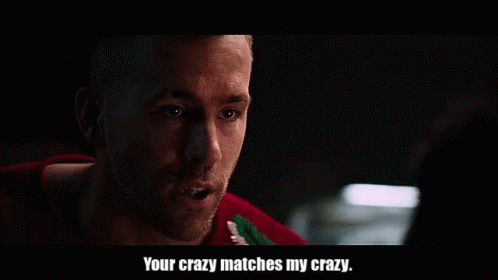 A Man In A Red Sweater Is Talking To Another Man In A Dark Room And Says `` Your Crazy Matches My Crazy '' . GIF