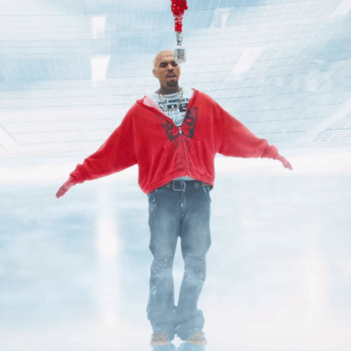 A Man In A Red Sweatshirt Is Holding A Microphone GIF