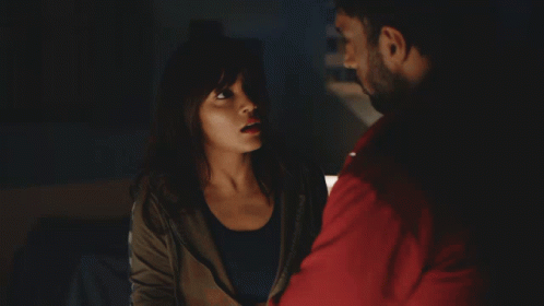 A Man In A Red Sweatshirt Sits At A Desk With A Woman GIF