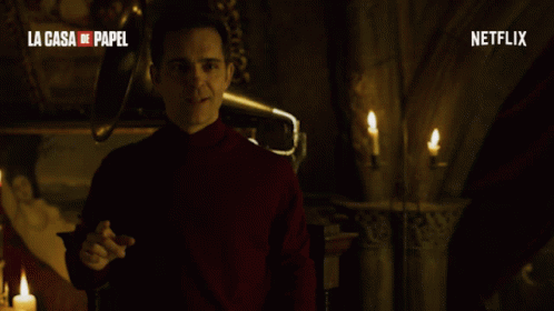A Man In A Red Turtleneck Stands In Front Of A Netflix Logo GIF