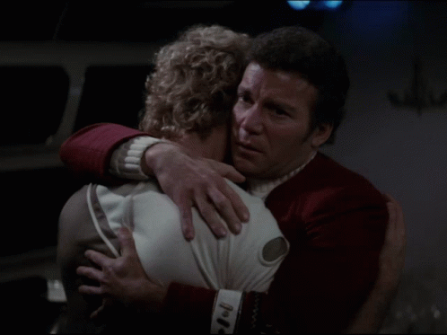 a man in a red uniform is hugging a woman