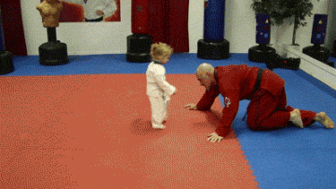 A Man In A Red Uniform Is Kneeling Down Next To A Little Boy GIF