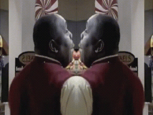 A Man In A Red Uniform Is Standing In Front Of A Sign That Says ' Pears ' GIF