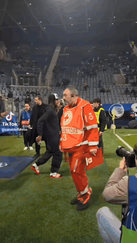 a man in a red uniform with the number 13 on it walks on a soccer field