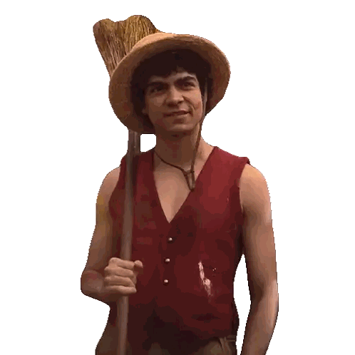 a man in a red vest and straw hat holds a broom