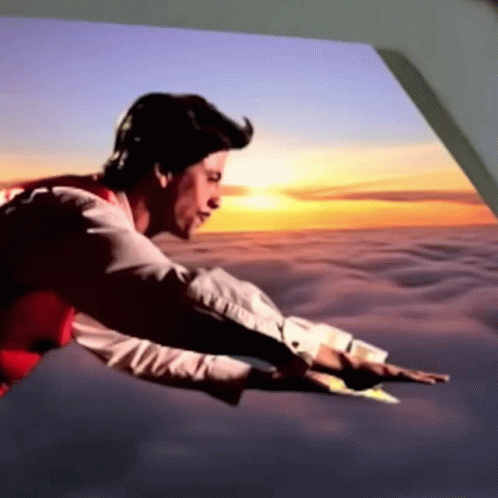 A Man In A Red Vest Is Flying Through The Air At Sunset GIF