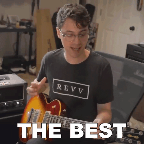 A Man In A Revv Shirt Playing A Guitar GIF