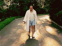 Man In Robe And Shorts Walking Down Dirt Road GIF