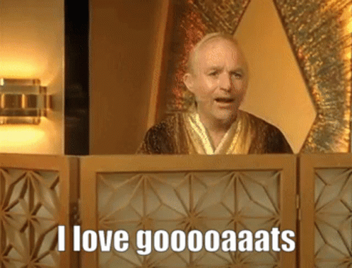 A Man In A Robe Behind A Wooden Screen Says I Love Goooooaats GIF