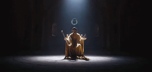 A Man In A Robe Is Sitting On A Throne With A Wreath On His Head GIF