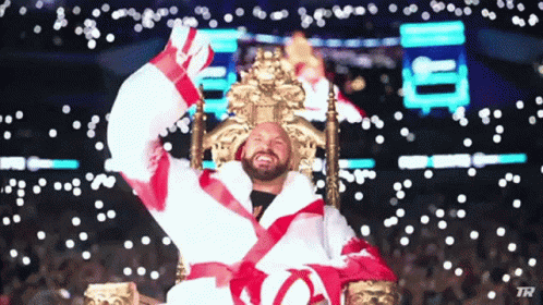 A Man In A Robe Is Sitting On A Throne With His Arms Up GIF