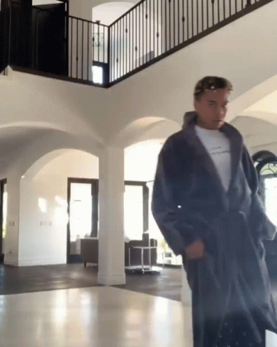 Man In Robe Standing In Hallway GIF