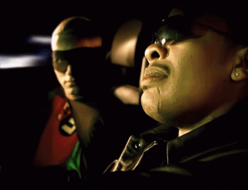 A Man In A Robin Costume Sits Next To Another Man In A Black Jacket GIF
