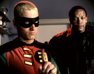 A Man In A Robin Costume With The Letter B On It GIF