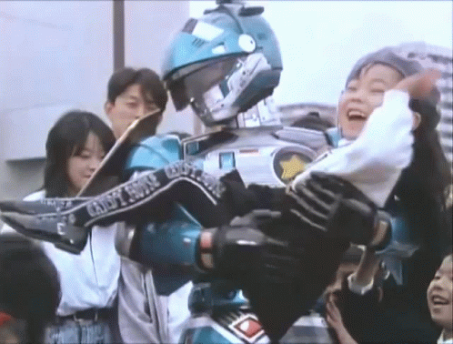 A Man In A Robot Costume Is Carrying A Woman In His Arms . GIF