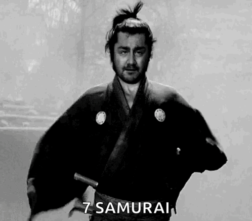 A Man In A Samurai Costume Is Holding A Sword In His Hand . GIF