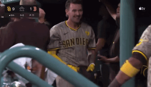 a man in a san diego jersey stands in front of a scoreboard