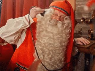 A Man In A Santa Claus Costume Is Talking On A Phone . GIF