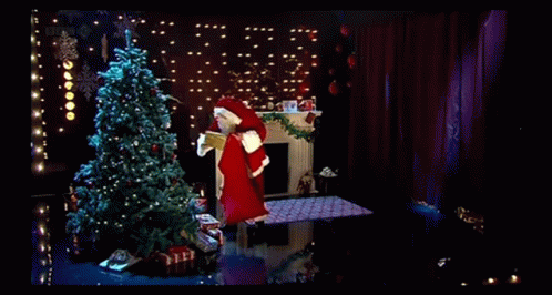 A Man In A Santa Suit Is Holding A Christmas Card With A Christmas Tree On It GIF