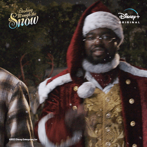 A Man In A Santa Suit Is Standing In Front Of A Sign That Says Dash Through The Snow GIF
