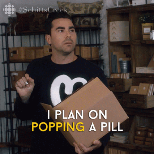 A Man In A Schitts Creek Sweater Holds A Cardboard Box GIF