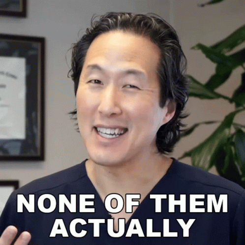 A Man In A Scrub Top Smiles With The Words None Of Them Actually Below Him GIF