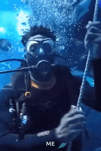 A Man In A Scuba Suit Is Holding A Rope Underwater And The Word Me Is Above Him GIF
