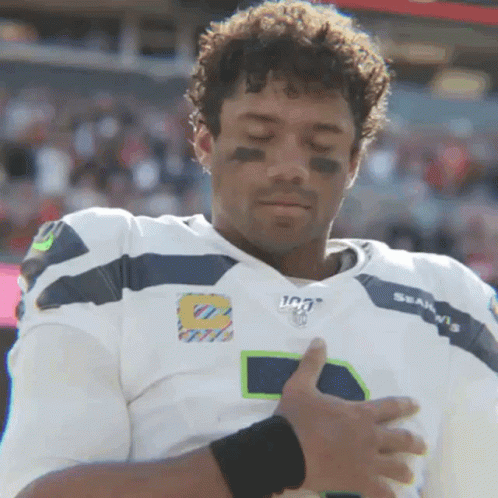 A Man In A Seahawks Jersey Holds His Hands Over His Heart GIF