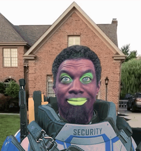 A Man In A Security Suit Is Smiling In Front Of A Brick Building GIF