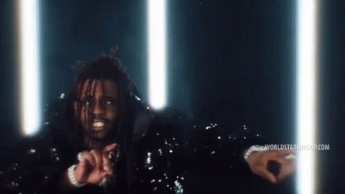 A Man In A Sequined Jacket Stands In Front Of A Worldstarhiphop.com Banner GIF