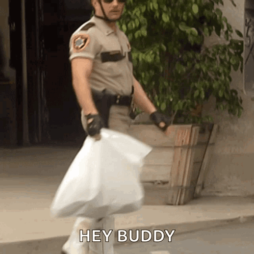 A Man In A Sheriff 'S Uniform Is Carrying A Large Bag And Says Hey Buddy GIF