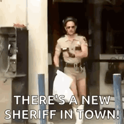 A Man In A Sheriff 'S Uniform Is Holding A Bag Of Trash . GIF