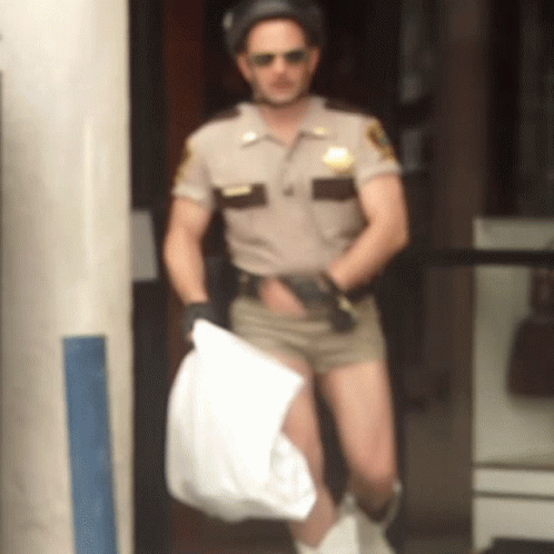 A Man In A Sheriff 'S Uniform Is Holding A Bag GIF